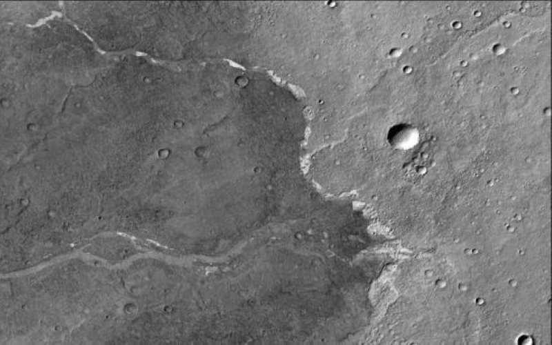 На этом изображении, полученном космическим аппаратом НАСА Mars Reconnaissance Orbiter, показано плато Bosporos Planum на Красной планете. Белые точки — это отложения соли, найденные в сухом канале, ключ к его водному прошлому.
