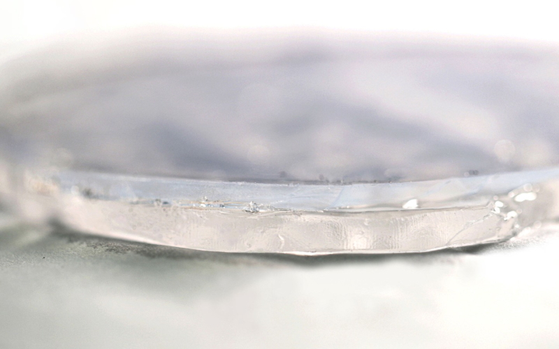 Двухслойный материал толщиной менее полдюйма (12 мм) состоит из гидрогеля внизу и аэрогеля вверху.